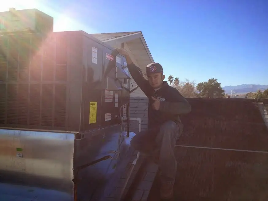 HVAC technician performing HVAC Inspection on a rooftop unit in Fallon